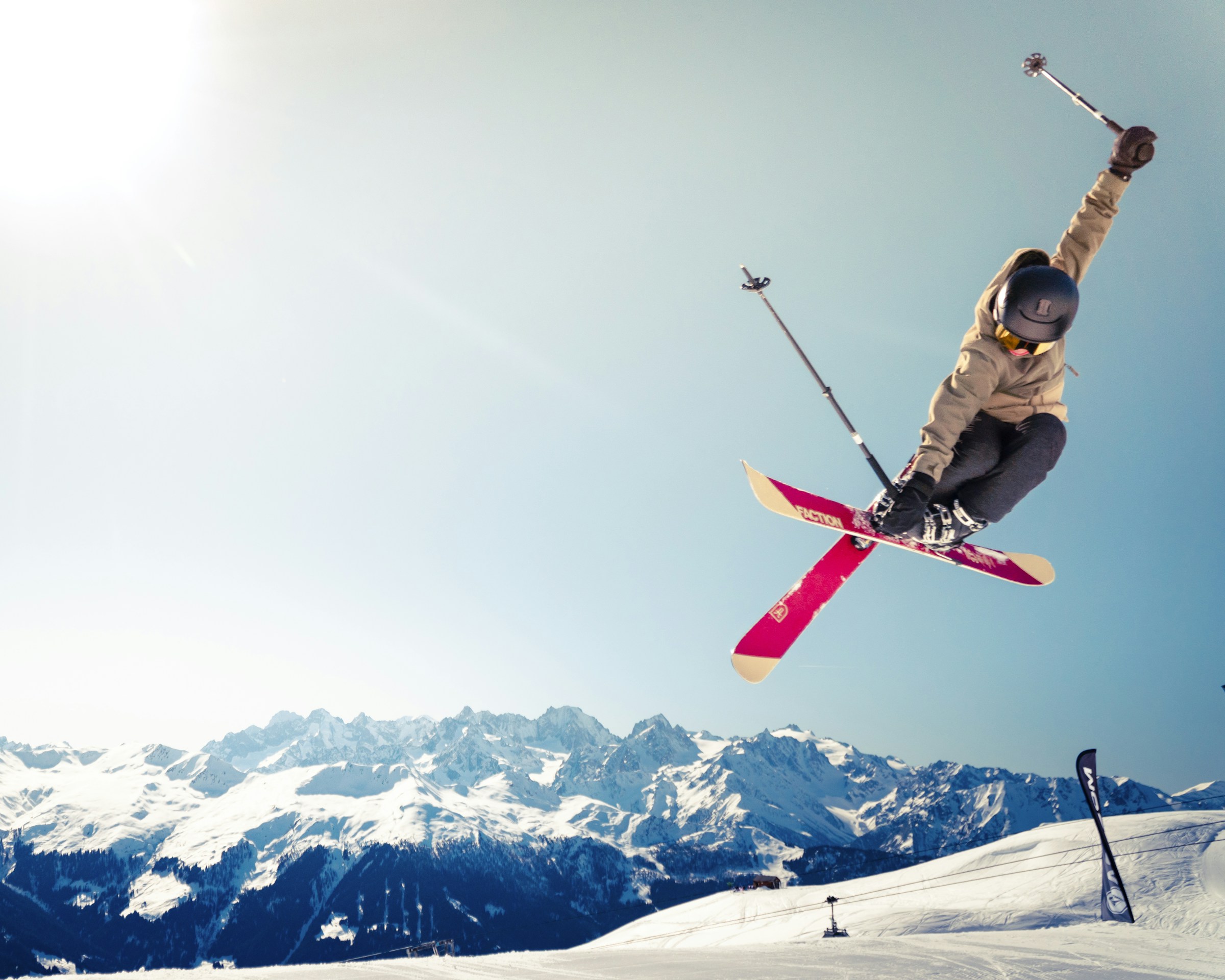 A skier carving downhill through deep powder at a mountain ski resort