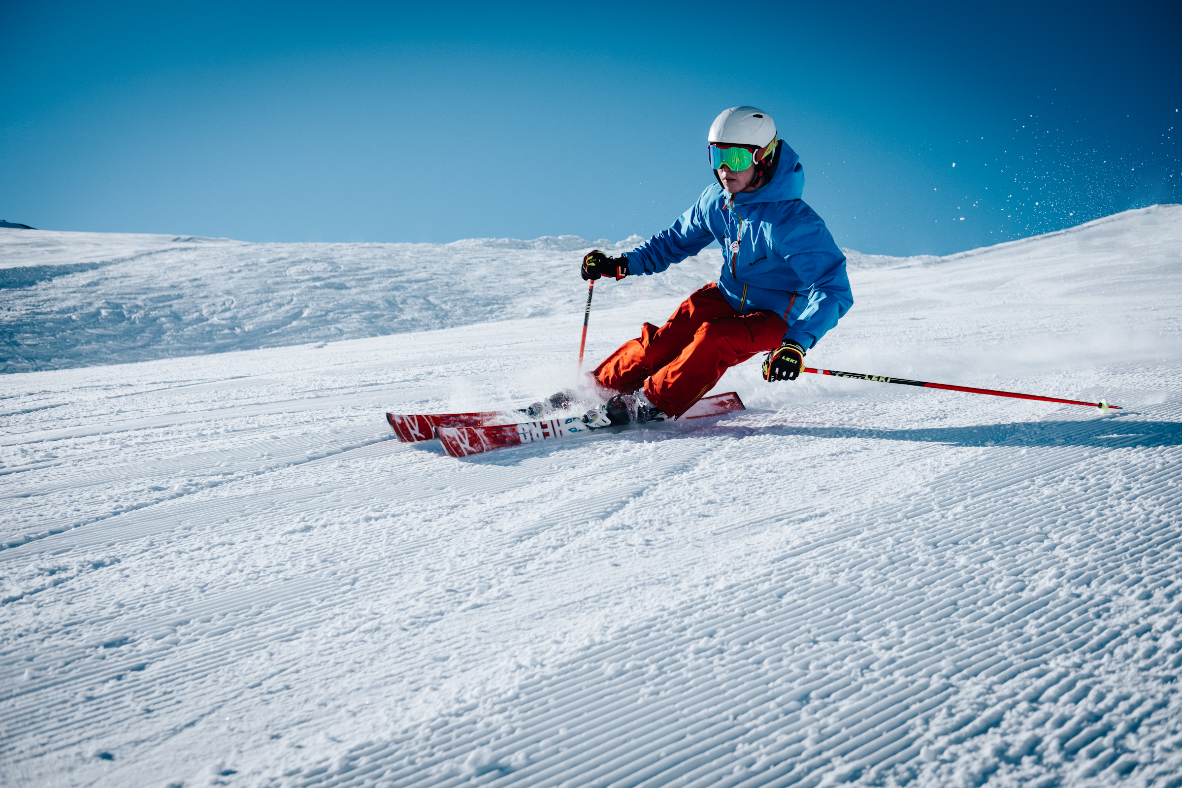 A skier carving through fresh powder on a sunny day